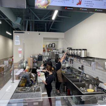 Hi Boba - Staff members are working behind the counter of a bright boba tea shop, preparing beverages with various ingredients and equipment. - Coffee & Tea Near Me - Rio Rancho, New Mexico
