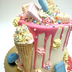 The Yummery - Candy themed cake. All buttercream with pink drip and custom chocolates