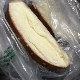 Pan de mantequilla. Pan dulce - A close-up of a slice of butter bread with a soft, pale interior and a brown crust, wrapped in clear plastic.