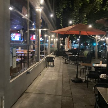 Hops & Sessions - Outdoor Seating with many tables to the right, but also showing one, of two large TVs, inside. (Photo from around 9:30pm) - Beer Bar Near Me - Livermore, California Hops & Sessions - Outdoor Seating with many tables to the right, but also showing one, of two large TVs, inside. (Photo from around 9:30pm) - Beer Bar Near Me - Livermore, California