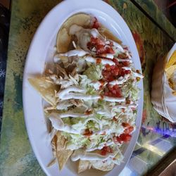 Tampico Mexican Restaurant - Nacho Supreme with Cheese and nachos piled with spicy beef, shredded chicken and beans, topped with lettuce, tomatoes, and sour cream