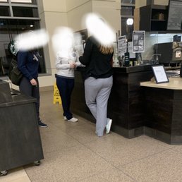 two people standing at a counter in a coffee shop two people standing at a counter in a coffee shop