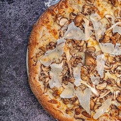 Carson's Pizzeria Niagara Falls - Our Fungi Pizza features a truffle Bechamel base, Mozzarella and Asiago cheese blend with Cremini and Oyster Mushrooms, topped with shaved P