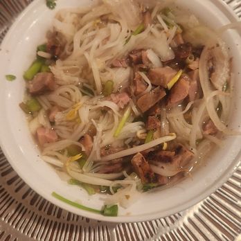 Hanco’s - A bowl of noodle soup containing sliced meat, bean sprouts, and chopped green onions, served on a decorative metal plate. - Vietnamese Near Me - Brooklyn, New York