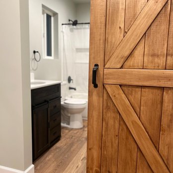 My Cali Builders - a bathroom with a wooden door - General Contractors Near Me - Los Angeles, California