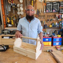 GTA WoodWorks - Man proudly holding a finished wooden toolbox at a Toronto woodworking class.