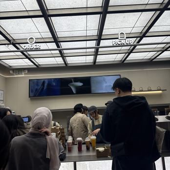HeyTea - People are gathered at a cafe counter with digital menu screens, waiting to order or pick up drinks, in a contemporary setting. - Bubble Tea Near Me - Tysons, Virginia