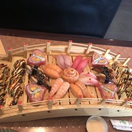 a variety of sushi on a wooden tray