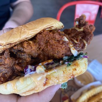 Dave's Hot Chicken - a hand holding a fried chicken sandwich - Chicken Shop Near Me - Menifee, California Dave's Hot Chicken - a hand holding a fried chicken sandwich - Chicken Shop Near Me - Menifee, California
