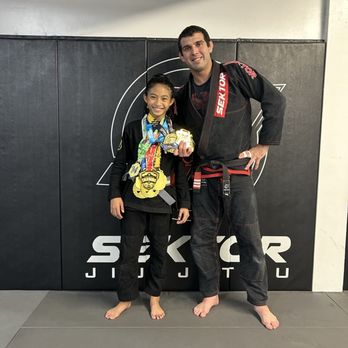 Sektor Jiu-jitsu - Sektor creates champions! My daughter with Professor Sean Roberts displaying all of her medals earned in 2023. - Brazilian Jiu-jitsu Near Me - Chino, California Sektor Jiu-jitsu - Sektor creates champions! My daughter with Professor Sean Roberts displaying all of her medals earned in 2023. - Brazilian Jiu-jitsu Near Me - Chino, California