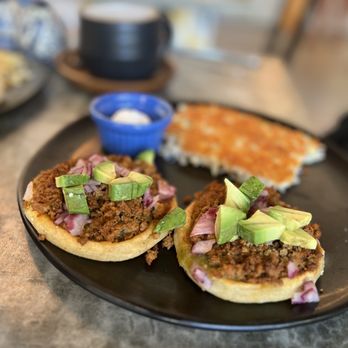 Chuponcito - Sopes Desayuno w/chorizo, onion, cilantro, avocado, with a tangy green sauce on a handmade sope and a side of delicate hash browns. - Mexican Near Me - Aliso Viejo, California Chuponcito - Sopes Desayuno w/chorizo, onion, cilantro, avocado, with a tangy green sauce on a handmade sope and a side of delicate hash browns. - Mexican Near Me - Aliso Viejo, California