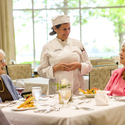 Plymouth Place - Residents a Plymouth Place enjoying dinner and conversing with the chef.