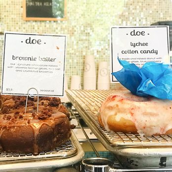 Doe Donuts - The brownie batter dipped in !actual! brownie batter, brownie pieces, and sea salt (Left), The Lychee Cotton Candy, real lychee glaze (Right - Donuts Near Me - Portland, Oregon