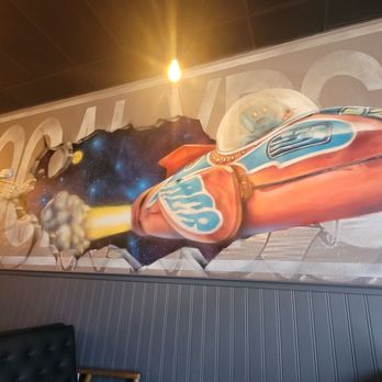 Apocalypse Coffee Roasters - The mascot robot on the left and a mural on the east wall. - Coffee Roasteries Near Me - West Melbourne, Florida
