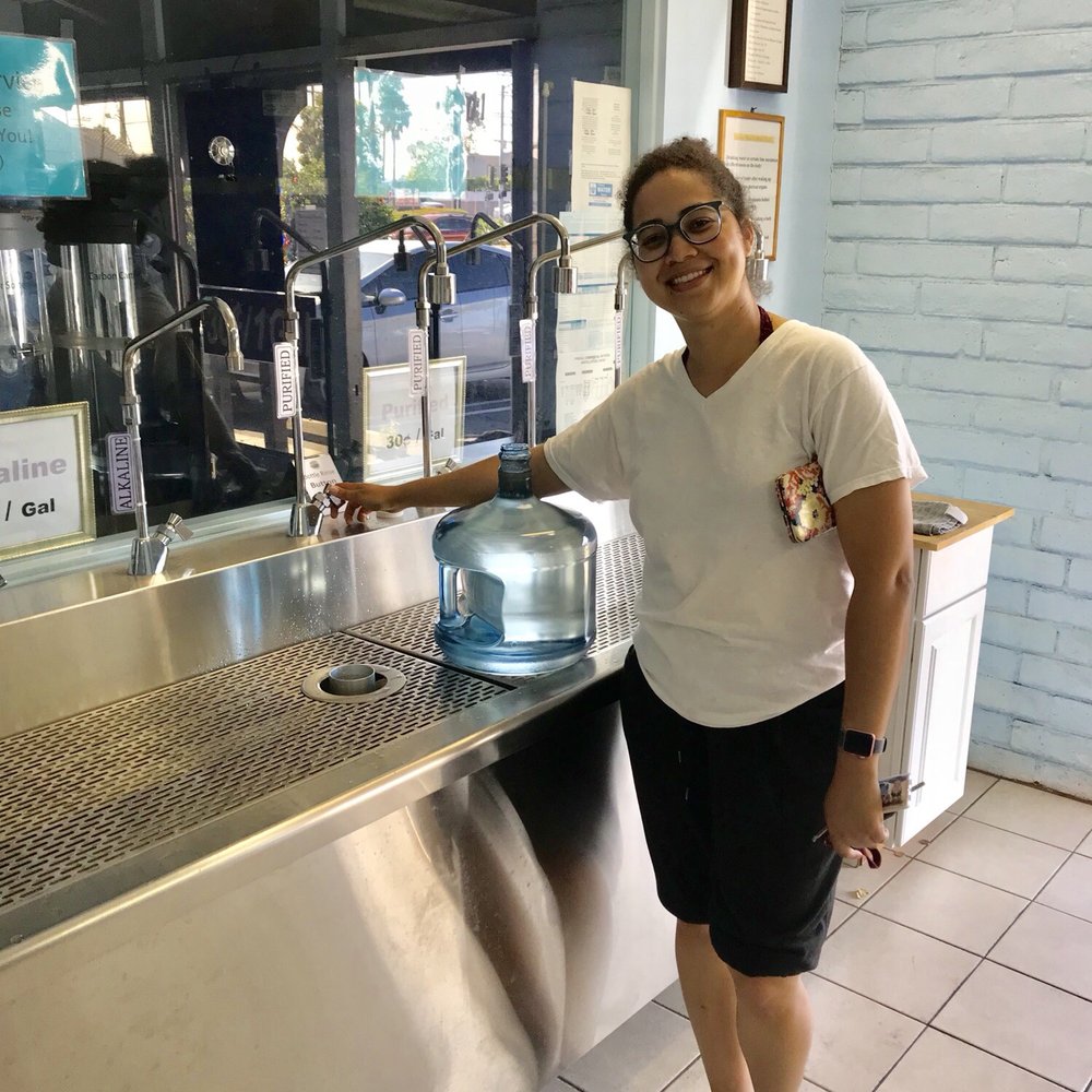 a woman standing in front of a water cooler a woman standing in front of a water cooler