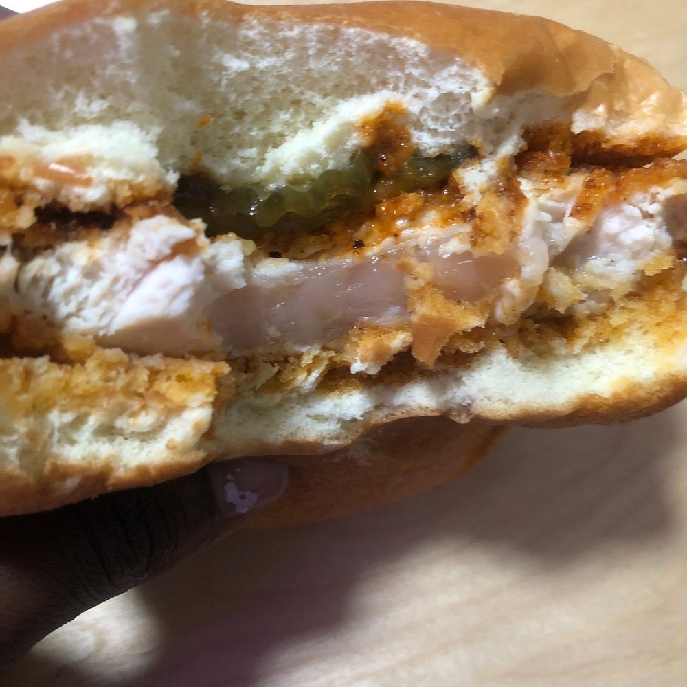 Wingstop - a hand holding a half eaten sandwich - Chicken Wings Near Me - Middle Village, New York Wingstop - a hand holding a half eaten sandwich - Chicken Wings Near Me - Middle Village, New York