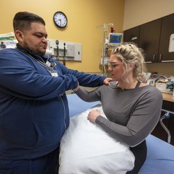 Complete Care Brooks City Base - Emergency nurse checking arm injury.