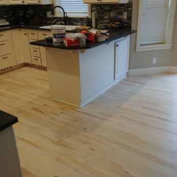 Touch Of Timber - a kitchen with white cabinets and black countertops - Flooring Near Me - Springfield, Oregon Touch Of Timber - a kitchen with white cabinets and black countertops - Flooring Near Me - Springfield, Oregon