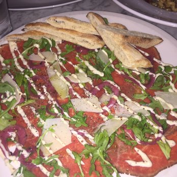 Trattoria by Italian Kitchen - Beef Carpaccio herb crusted beef, grainy mustard aioli, arugula, grana padano, forno bread, pickled onions - Italian Near Me - Burnaby, British Columbia Trattoria by Italian Kitchen - Beef Carpaccio herb crusted beef, grainy mustard aioli, arugula, grana padano, forno bread, pickled onions - Italian Near Me - Burnaby, British Columbia