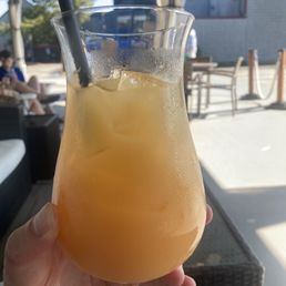 a person holding a glass of orange juice