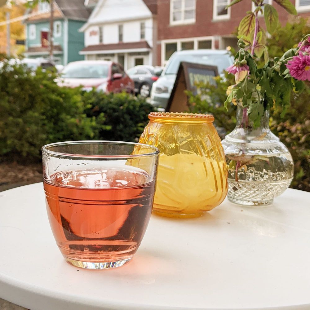 a glass of tea and a vase of flowers a glass of tea and a vase of flowers