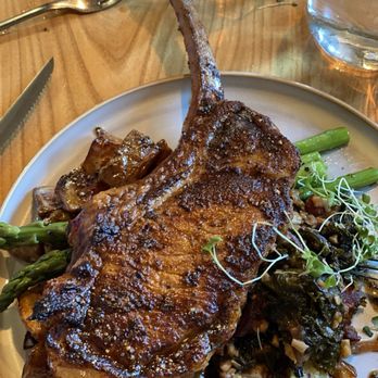 The Driftless Cafe - ST. BRIGID'S MEADOWS PORK CHOP*, SMOKED MAPLE AND CRACKED PEPPER GLAZE, SALT AND VINEGAR SMASHED POTATO, KEEWAYDIN FARMS BRAISED KALE - Sandwiches Near Me - Viroqua, Wisconsin