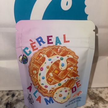 Cookies Modesto Dispensary - A pastel-colored package featuring a cookie design and rainbow-colored text reading 'CEREAL A LA MODE,' placed on a granite countertop. - Cannabis Dispensaries Near Me - Modesto, California