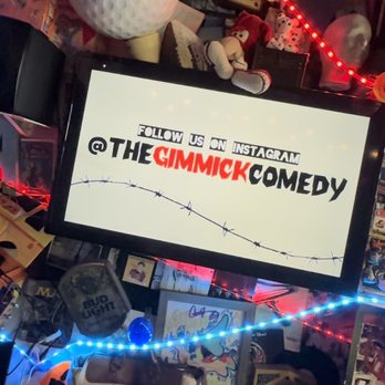 The Gimmick - a man holding a sign - Comedy Clubs Near Me - Tampa Bay, Florida The Gimmick - a man holding a sign - Comedy Clubs Near Me - Tampa Bay, Florida