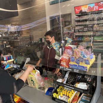 7-Eleven - a man at the cash register in a grocery store - Convenience Stores Near Me - Bedford, Texas