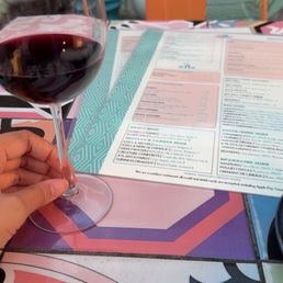 Glass of Piatelli Cabernet Sauvignon wine & patio seating.