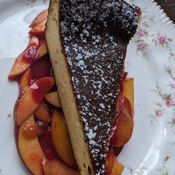 Joe Beef - Basque cheesecake on a bed of sliced peaches in a raspberry glaze - Seafood Near Me - Montreal, Quebec Joe Beef - Basque cheesecake on a bed of sliced peaches in a raspberry glaze - Seafood Near Me - Montreal, Quebec