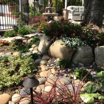 Sculptured Gardens Alive - Shaded Patio Garden with boulders and river stones built around large Carob Tree in West Hills. - Landscaping Near Me Sculptured Gardens Alive - Shaded Patio Garden with boulders and river stones built around large Carob Tree in West Hills. - Landscaping Near Me