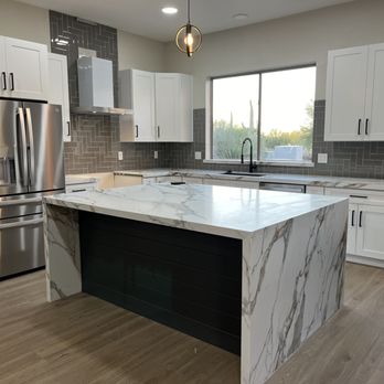 Salazar Contracting - a kitchen with a marble island and stainless steel appliances - General Contractors Near Me Salazar Contracting - a kitchen with a marble island and stainless steel appliances - General Contractors Near Me