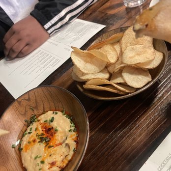 Spinning Bones - chips 'n dip (hummus w/chili oil + chives) and house made potato chips - New American Near Me - Alameda, California Spinning Bones - chips 'n dip (hummus w/chili oil + chives) and house made potato chips - New American Near Me - Alameda, California