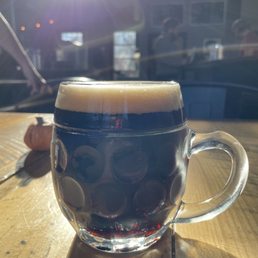 a glass of beer on a wooden table