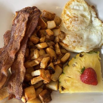Moena Café - MC Breakfast with crispy bacon, over easy eggs, country potatoes and pineapple + strawberry - Cafes Near Me - Honolulu, Hawaii Moena Café - MC Breakfast with crispy bacon, over easy eggs, country potatoes and pineapple + strawberry - Cafes Near Me - Honolulu, Hawaii