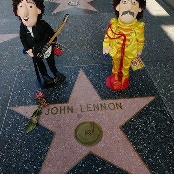 Capitol Records Tower - Beatle dolls John Lennon on his star at Capitol Records in Hollywood early Beatles in black suit and Sergeant Pepper's uniform - Landmarks & Historical Buildings Near Me - Hollywood, California