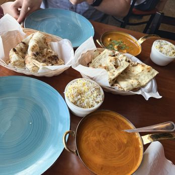 Naan Stop - Closest: Medium Mango Curry. Middle: Garlic Naan and Butter Naan Far: Tikka Masala - Indian Near Me - Wichita, Kansas