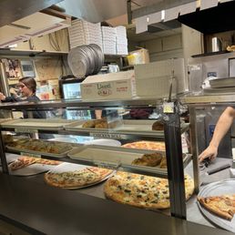 a man preparing pizzas in a kitchen