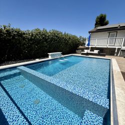Waterfall Pools - Modern custom build pool and spa with fully tiled spa and baja shelf