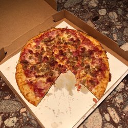 Carlo's Pizza - Meat lovers, Large, with a couple of slices eaten