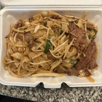 Yummy Box - Beef chow fun - A foam takeout container holds beef chow fun with flat rice noodles, beef slices, and green onions. - Chinese Near Me - Gilbert, Arizona