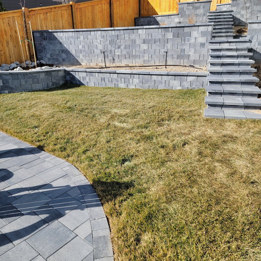 System Pavers - 3 retaining walls (2 with a raised seated edge for safety) and steps with lighting integrated. Shown pre-landscaping. - Masonry/Concrete Near Me - Denver, Colorado