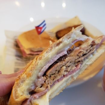 Ku-Va - a hand holding a half eaten sandwich - Cuban Near Me - Miami, Florida Ku-Va - a hand holding a half eaten sandwich - Cuban Near Me - Miami, Florida