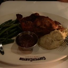 Rotisserie Chicken, Green Beans, Mashed Potatoes - A dinner plate from Copper Canyon Grill features rotisserie chicken, green beans, mashed potatoes with gravy, and a small container of sauce.