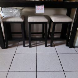 A kitchen table with an outlet and a phone charger at the end