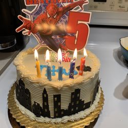 QFC - I decorated the cake with the topper and cityscape- not the store. She wrote Titus and added the spider.