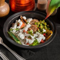 Olympia Cafe - Mediterranean Chicken Bowl served  Jasmine rice, Romaine lettuce, topped with tomatoes, cucumbers,  onions, peppers chick peas & Tzatziki