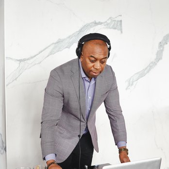 Copper Spirits & Sights - a man in a suit and headphones mixing music on a laptop - Cocktail Bars Near Me - Ottawa, Ontario
