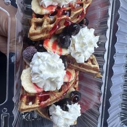 Protein waffles with bananas and blueberries, Carmel and strawberry drizzle.